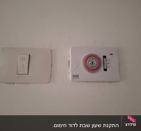 מתג חשמל וטיימר על קיר לבן